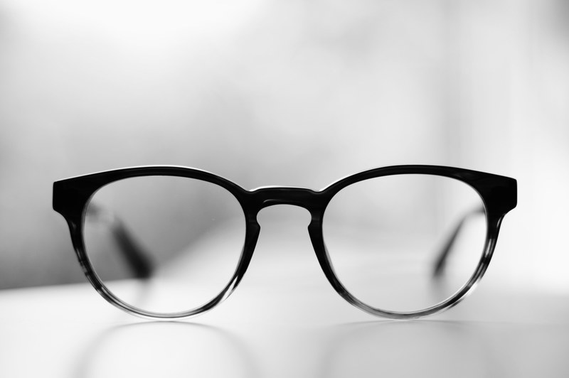 a pair of glasses in black frames on a white surface, warby parker percey 4k