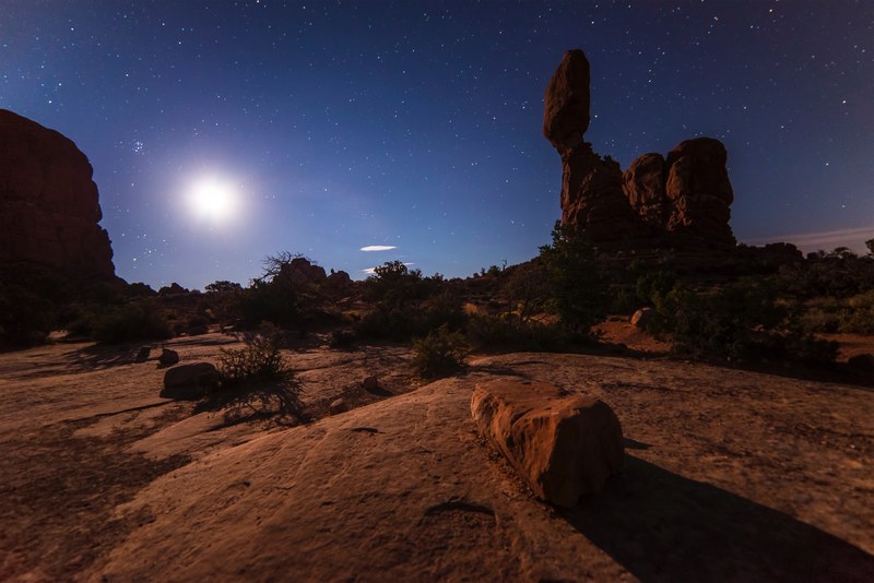 setting sun on a starry sky over a red desert with large rock formations, starry sunset over the desert 4k
