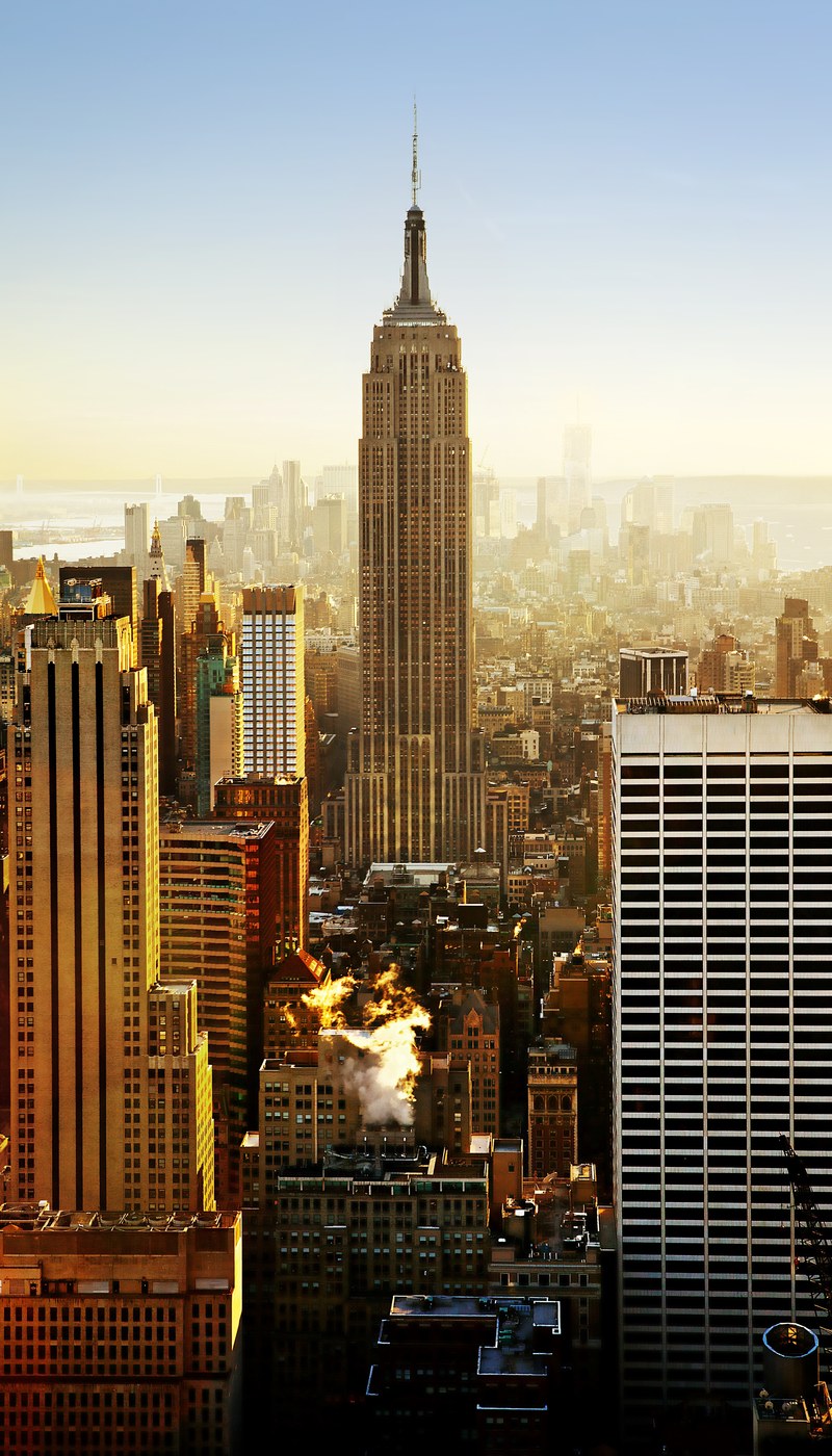 view of the empire state building between skyscrapers in the new york city skyline, stand tall 4k
