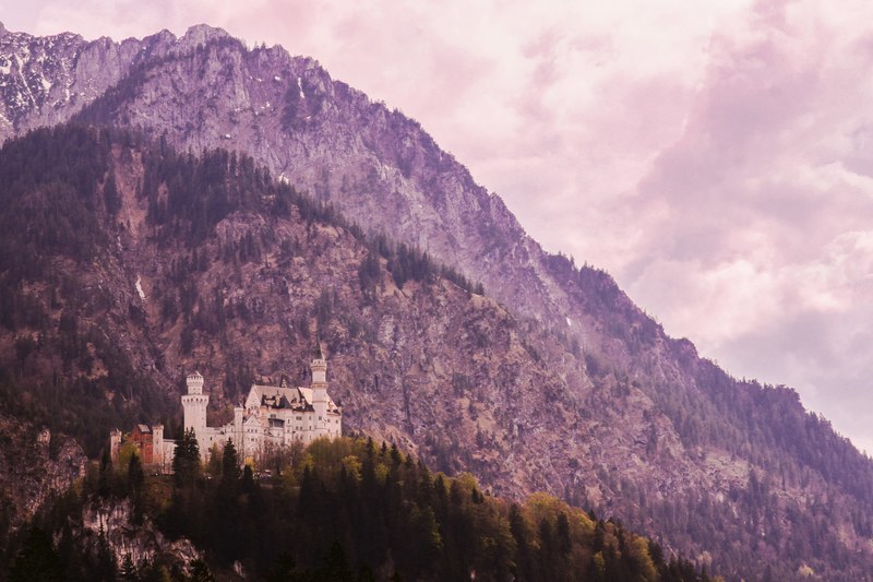 tall purple hued mountain towering over neuschwanstein castle, hdr to the limit 4k