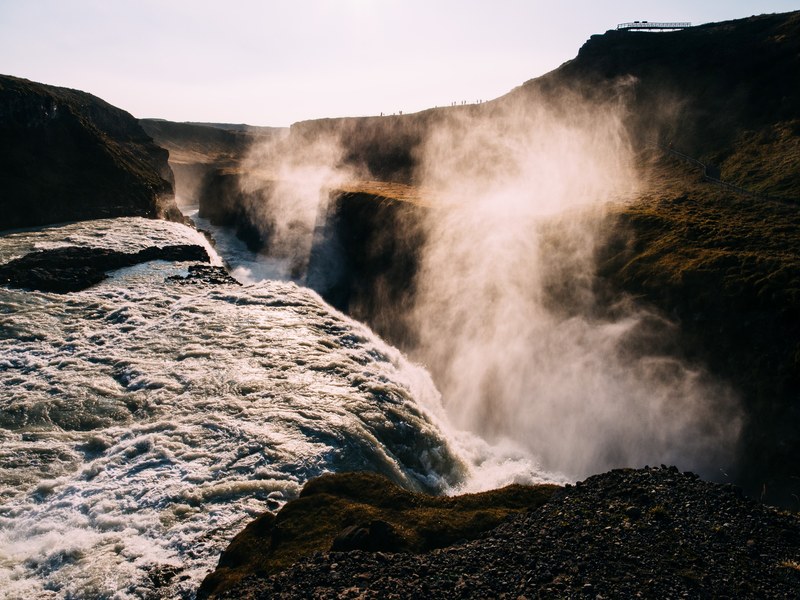 water spraying over a massive waterfall pouring down into a ravine, steamy waterfall 4k