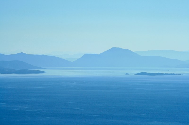 blue rolling mountains covered in calm clouds and fog, fog on the island 4k