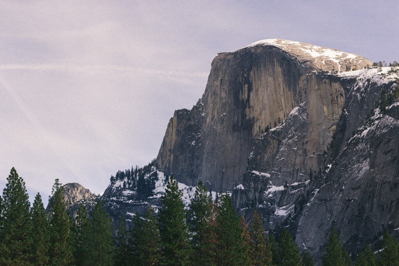 snow dusted mountain tops next to a forest of trees in yosemite valley, _snow mountain tops in yosemite valley 4k