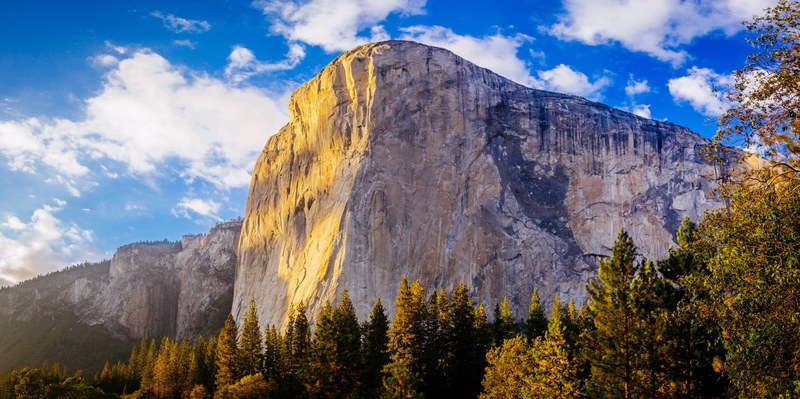 sunlight illuminates the face of the el capitan rock formation in yosemite, el capitan on a sunny day 4k
