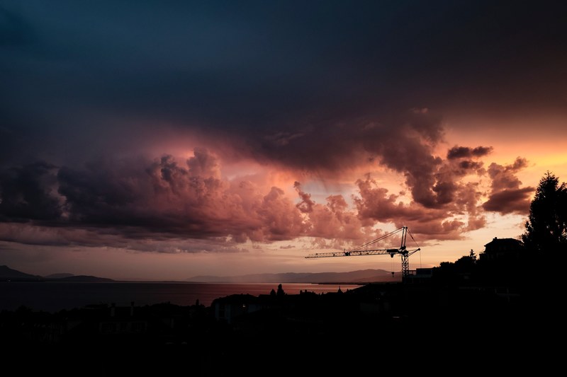 a distant crane and coastal landscape with an overcast cloudy sky at sunset lausanne, crane and clouds 4k