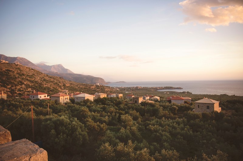 a picturesque landscape with small houses between thick shrubs on the sea coast, sea village behind shrubs 4k