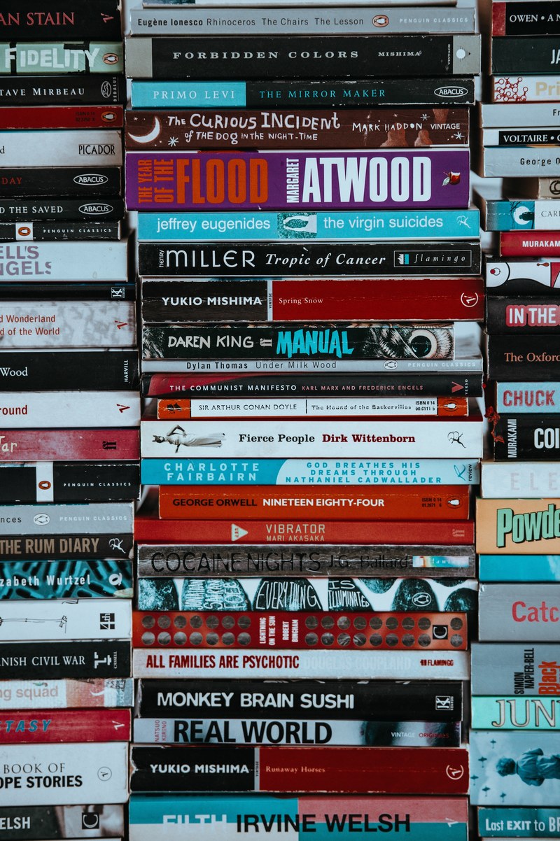 a large collection of books stacked on top of each other, portrait shot of piles of books 4k
