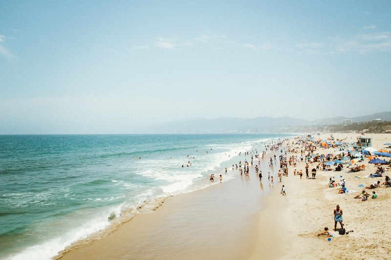 a crowded beach on a sunny day in santa monica, vacation in santa monica 4k