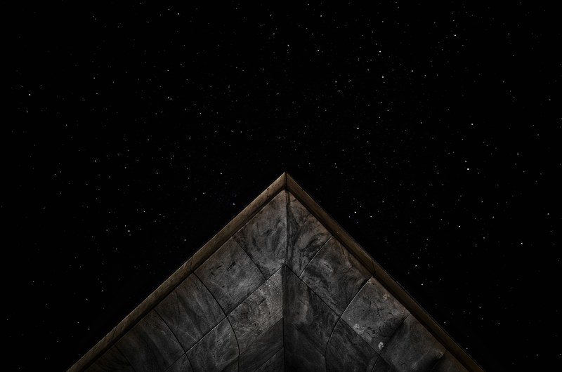 the peak of the roof of a stone building against the starry night in sardegna, _peak roof sardagna night 4k