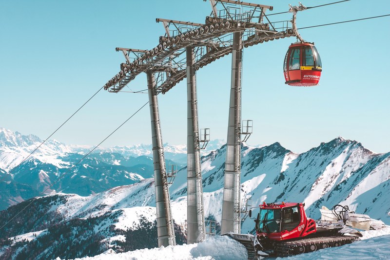 snow lift at a ski resort in kaprun with a bulldozer pushing snow below, icebreaker 4k