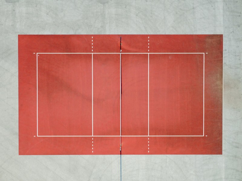 a drone shot of a red tennis court, minimalvolleyball 4k