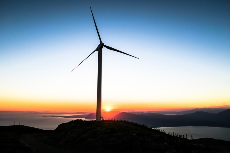 sun setting below a spinning windmill turbine in patras, sunset below patras windmill 4k