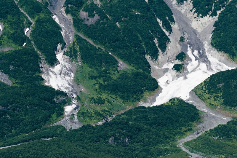 a drone shot of a woods on rocky hills, green rocky hills from above 4k