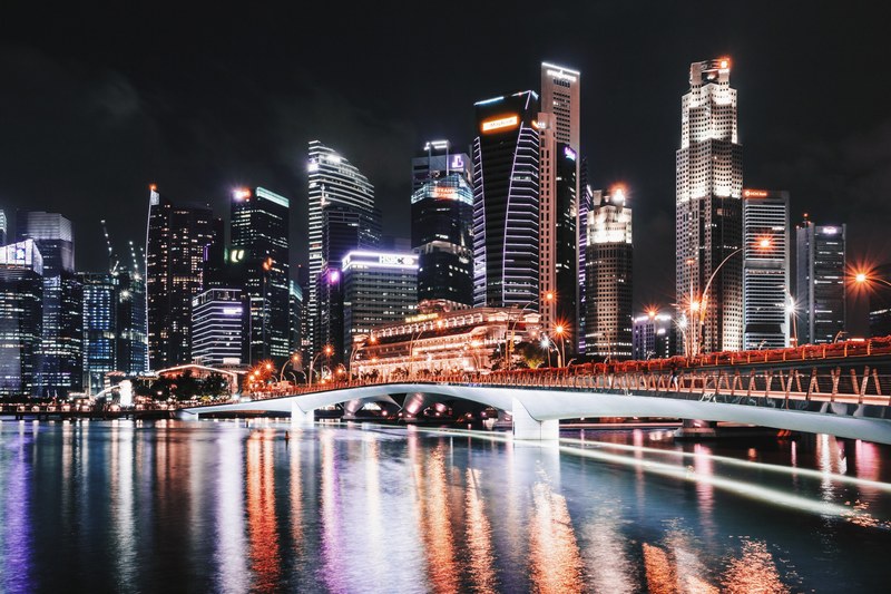 illuminated skyscrapers near a white steel bridge at singapores waterfront, lion city waterfront 4k