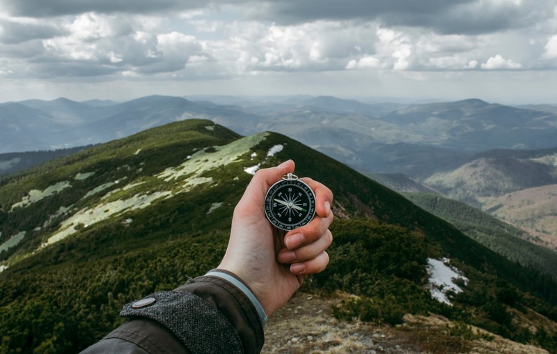 a person holding a compass while standing on a ridge in the carpathian mountains, mountains is always right destination 4k