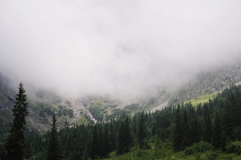 heavy mist rolling down mountain slopes, mountain behind mist 4k