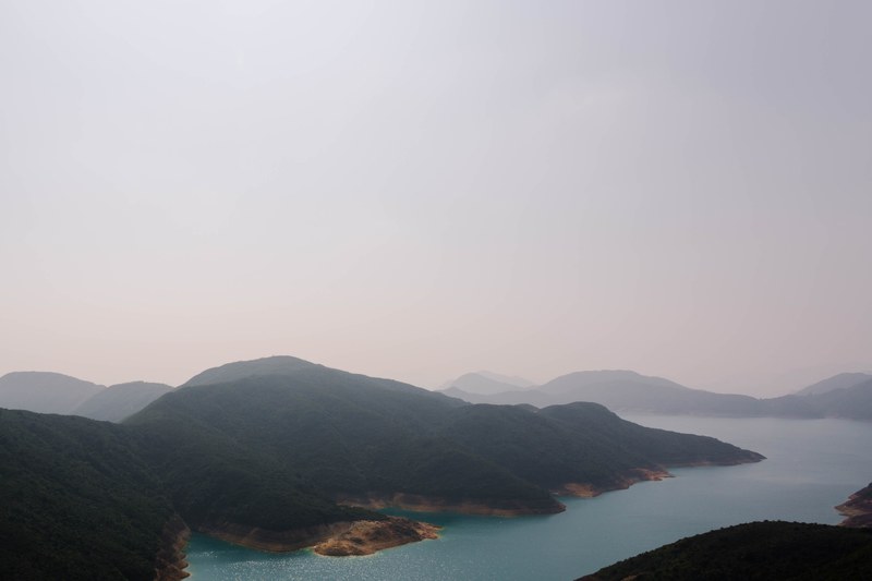 a high view of an azure river surrounded by wooded hills in hong kong, river flowing through hills 4k