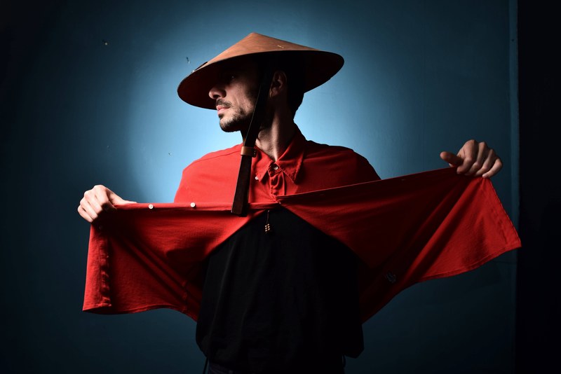 a man is modeling in an asian conical hat and a red shirt in yerevan, _male model yerevan 4k