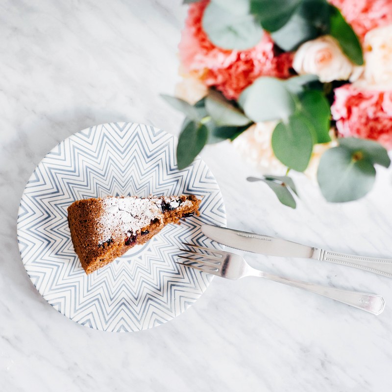 an overhead shot of a slice of cake on a plate next to a floral bouquet, pie 4k