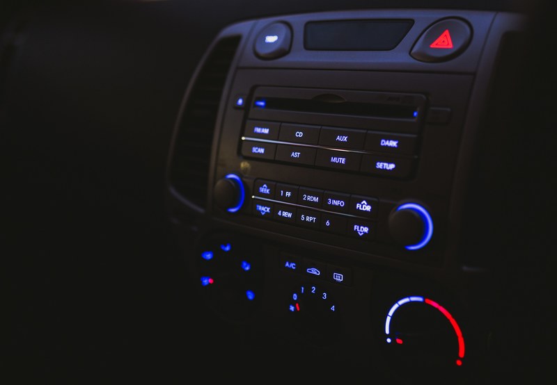 a dim shot of a car radio with gauges and buttons lighting up in red and blue, listening to car radio 4k