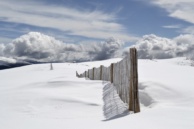 the end of a wooden fence traveling along a snow covered mountain, fence on snowy mountain 4k