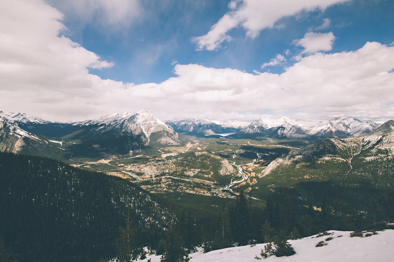 view from a mountain side on a town on a river in a mountain valley, peaceful mountain town 4k