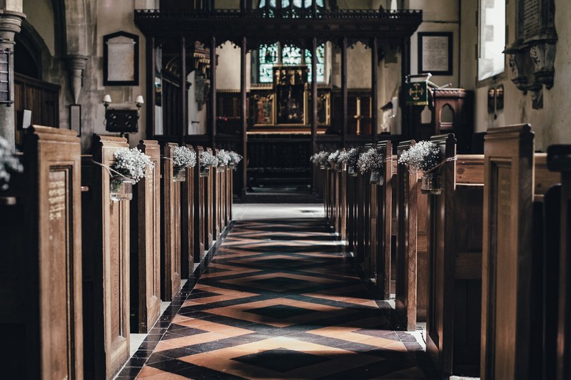 church aisle with wooden benches and tile floor leading towards the wedding altar, wedding aisle in old church 4k