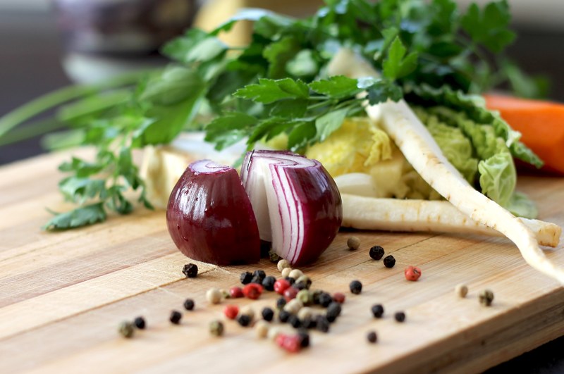 sliced onion parsnip carrots and spices on a cutting board, cooking ingredients 4k