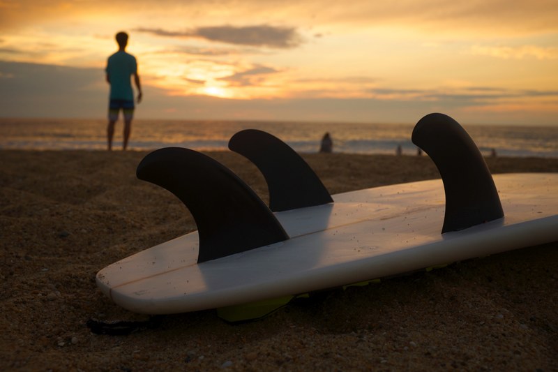 surfboard fins on the sand beach during sunset, the end of a surfing day 4k