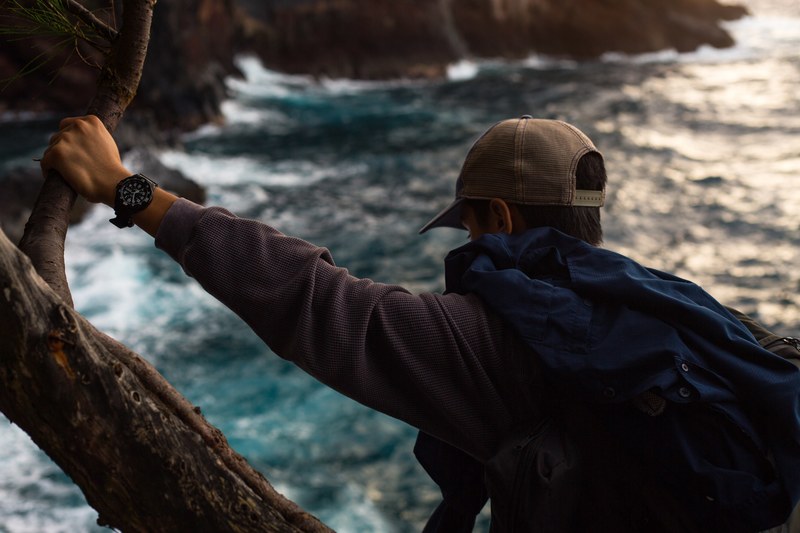 man wearing watch and hiking equipment standing on tree over water, hiking man with watch 4k