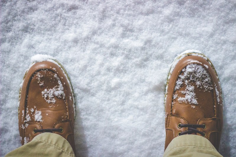 macro shot of a mans shoes with snow on them taken in battle creek, snow on feet and ground 4k