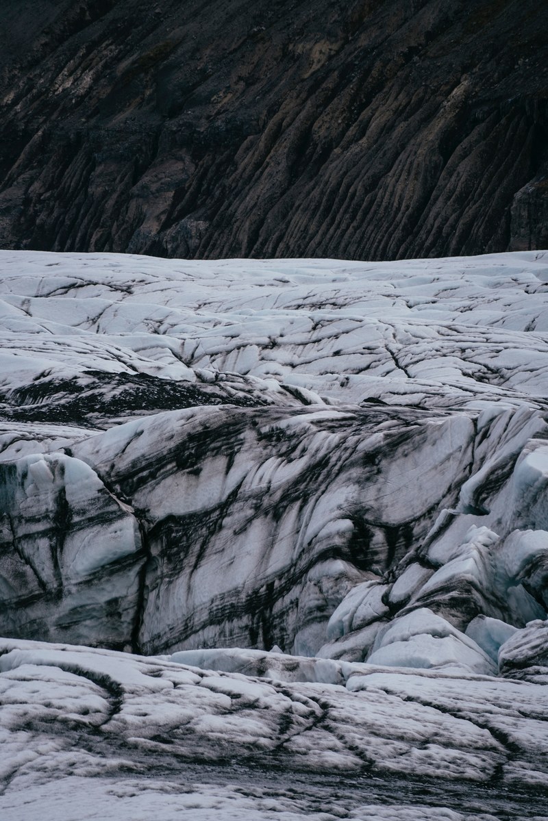 a white icy glacier with dark crevices, rugged glacier 4k