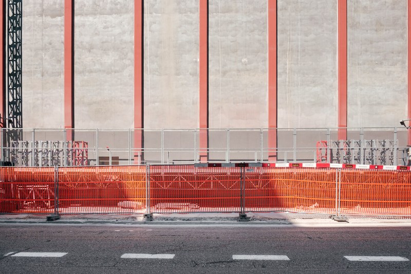 orange beams form lines outside an urban construction site, orange construction grids 4k