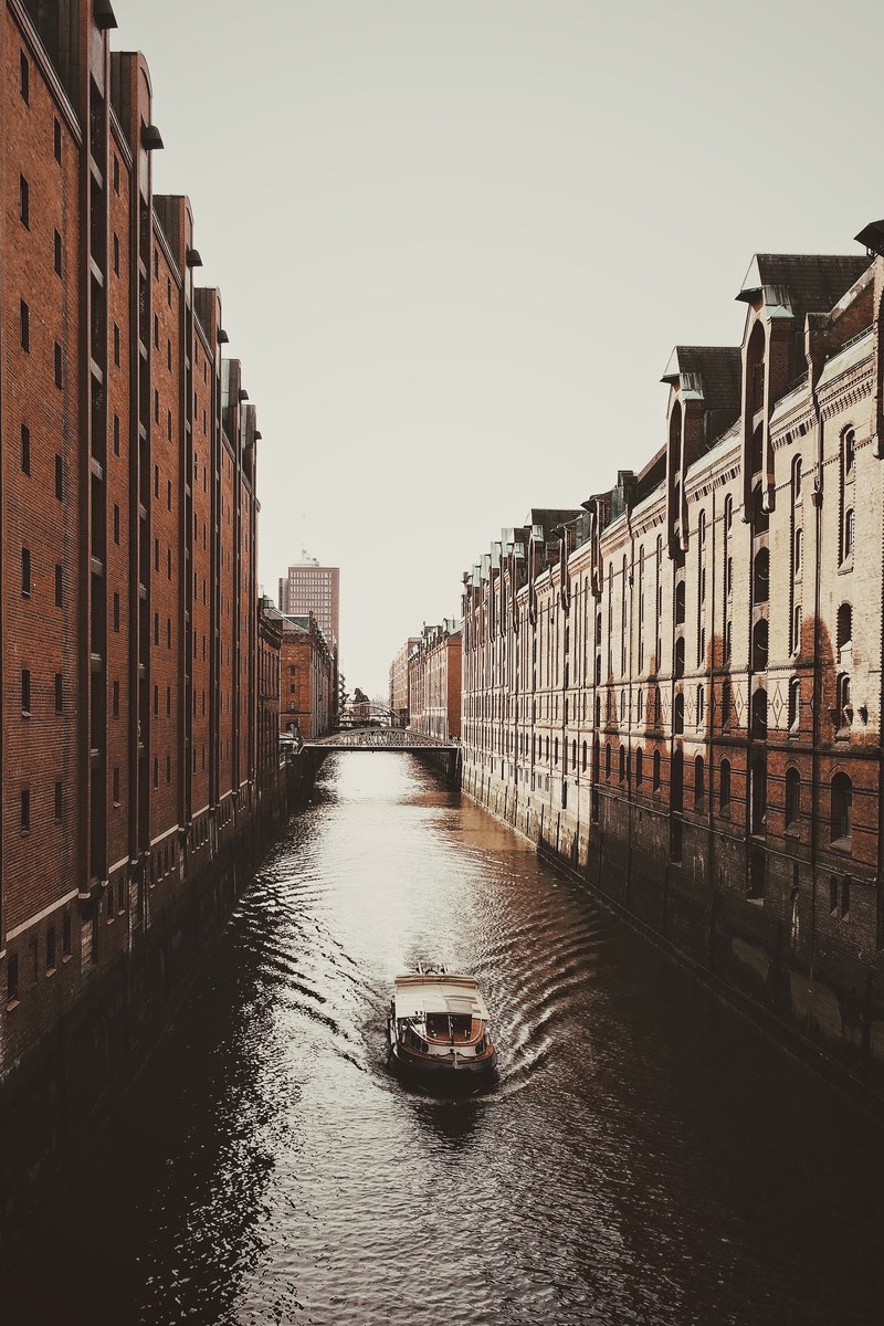 a boat on a canal in hafencity on a cloudy day, hafencity canal 4k