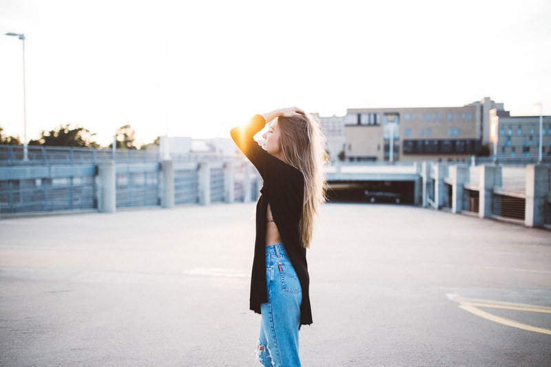 woman in a long black sweater poses on a parking garage at the university of arkansas, woman posing on parking garage 4k