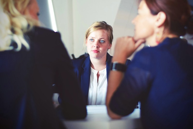 three businesswomen talking at a white table, three businesswomen 4k