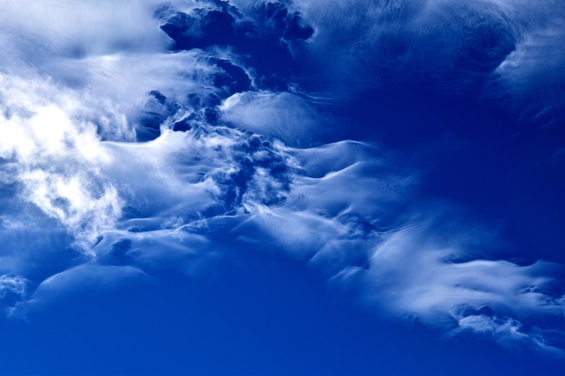 the blue sky above a playful veil of clouds, clouds on a bright blue sky 4k
