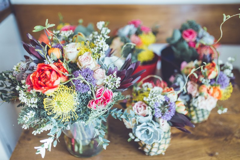 an arrangement of several floral bouquets with colorful flowers in small vases and pots, flower power 4k