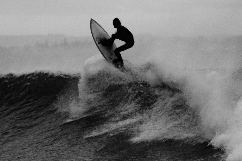 a black and white photo of a surfer catching waves at point leo, monochrome surfer on wave 4k