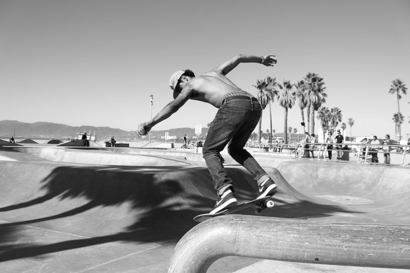 a shirtless man skateboarding at the venice beach skatepark, venice skateboarder on ramp 4k