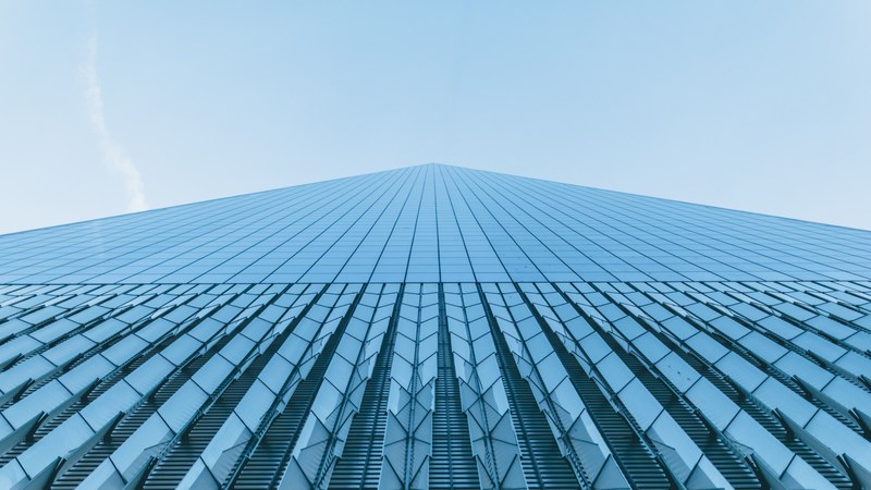 a low angle shot of a towering skyscraper with a glass facade, impressive tall skyscraper 4k