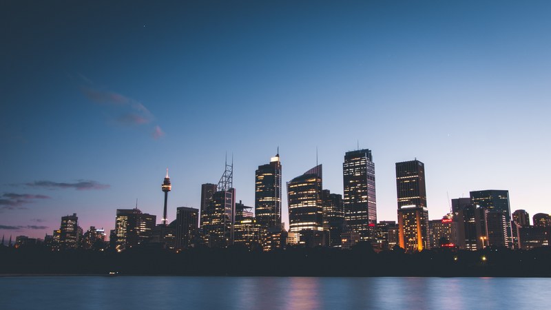 a metropolitan skyline seen from the water in the evening, metropolitan skyline 4k