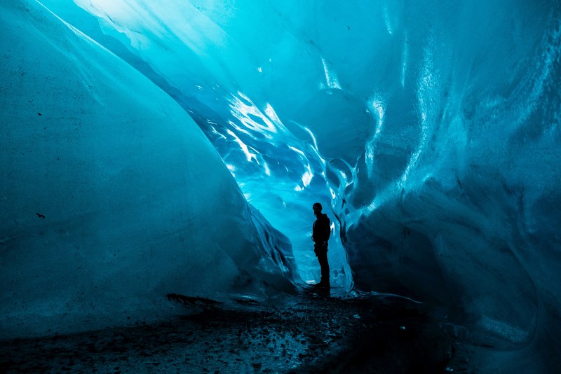 man standing in blue aqua glacier cave tunnel in iceland vatnajkull national park, glacier cave man iceland 4k