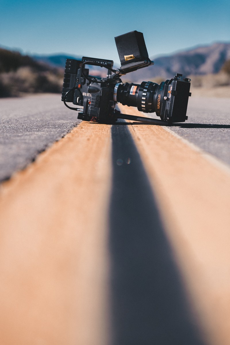 a professional dslr camera in the middle of an empty road, film in the desert 4k