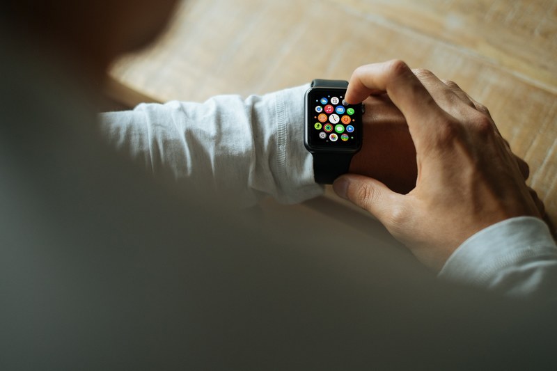 a man in a white sweater wearing and using an apple watch with a black band, man using black apple watch 4k