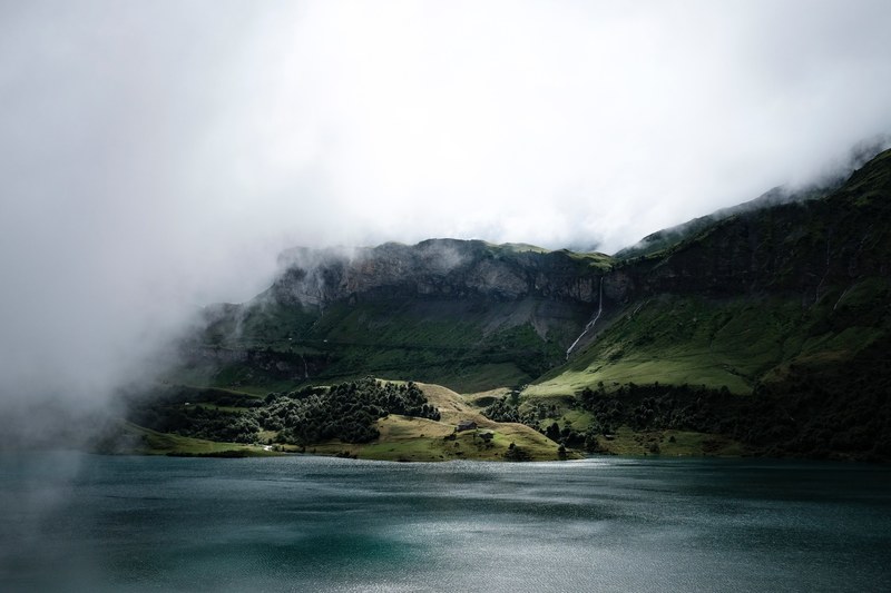 grassy mountainside by the lake on a misty morning, foggy vistas 4k