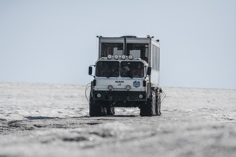 a white truck with a metal cube container with windows in it driving down a barren white wasteland, truck in a wasteland 4k
