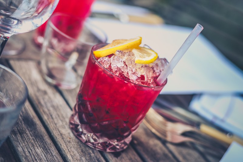 a cranberry cocktail beverage juice with ice and straw in a glass cup, cocktail beverage juice 4k