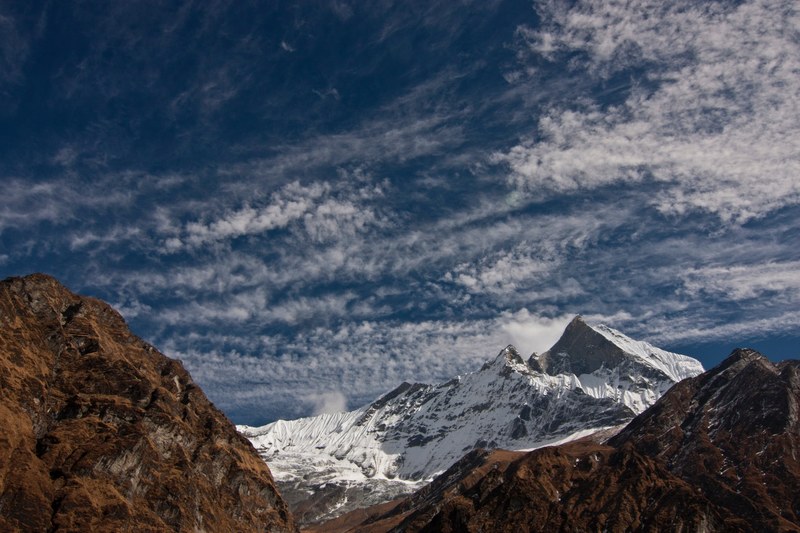 light clouds in the sky above a mighty mountain near machhapuchhre base camp, tall himalayan mountain 4k