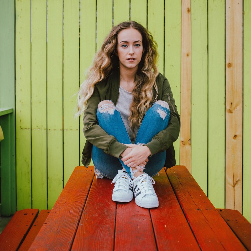 a woman sitting on a picnic table, _picture of me by seth doyle 4k